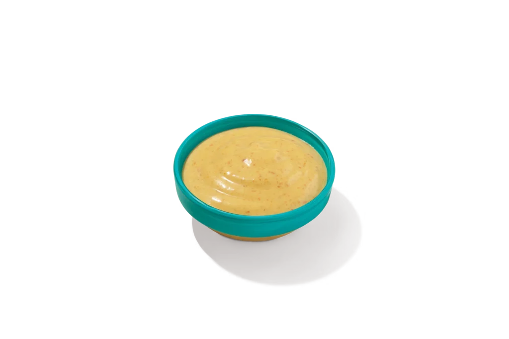 "Bowl of Wild Honey Mustard on a white background."