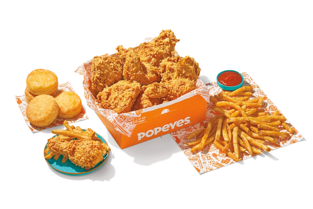 "8Pc Chicken Family Meal with crispy fried chicken, fries, biscuits, dipping sauce, and Popeyes packaging."