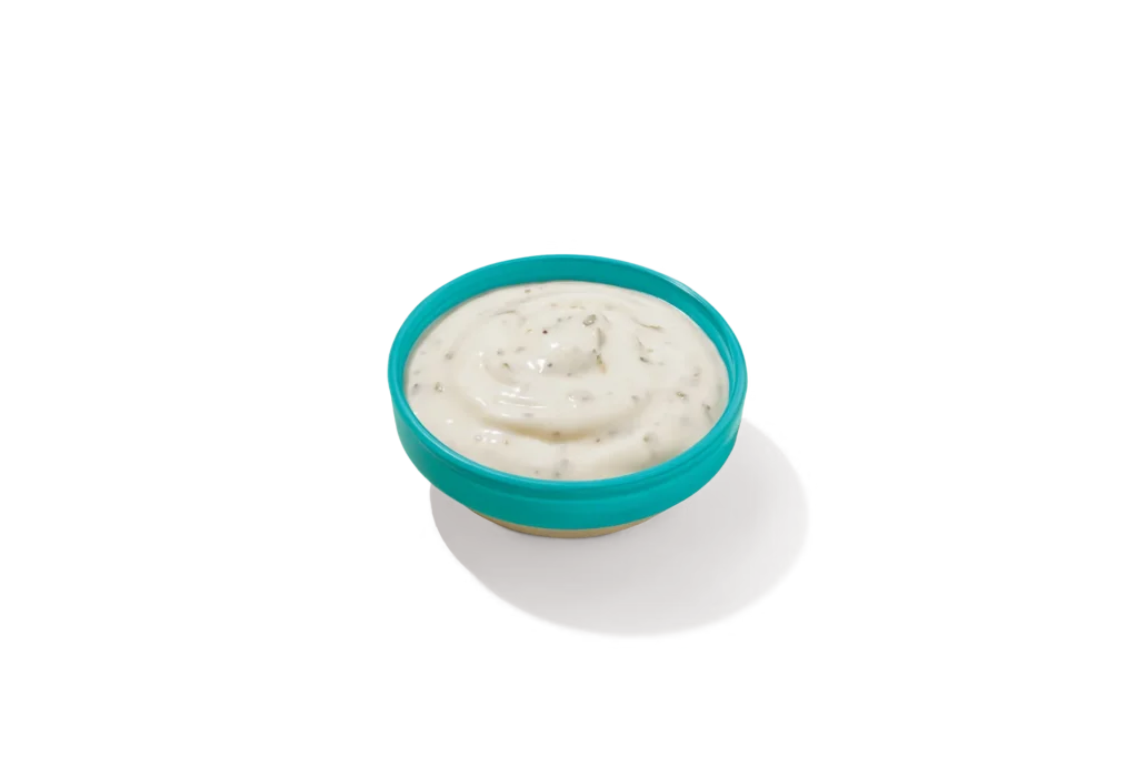 "Bowl of Buttermilk Ranch Sauce on a white background."
