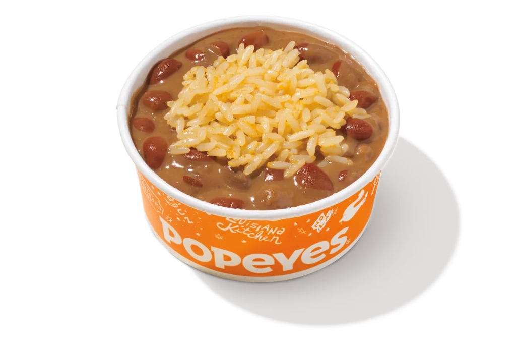 "Popeyes Red Beans & Rice with shredded cheese in an orange container."
