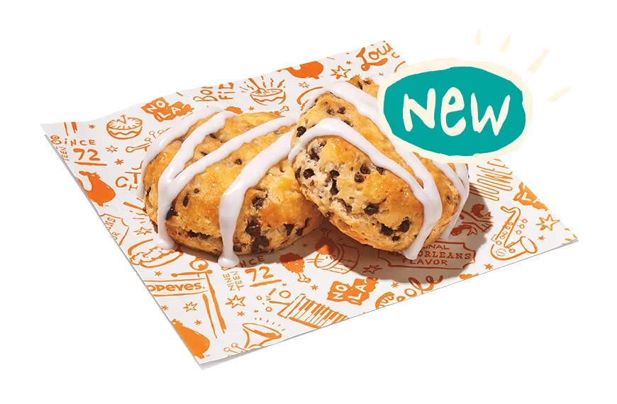 "Two chocolate chip cookies with icing drizzle on branded paper, labeled 'Desserts.'"