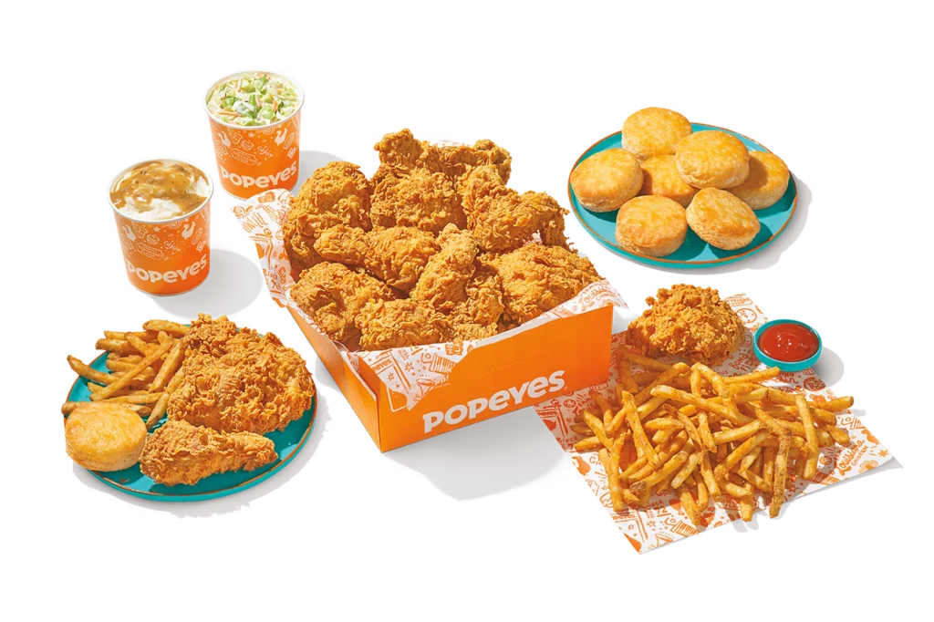 "16Pc Chicken Family Meal with crispy fried chicken, fries, biscuits, dipping sauce, and drinks in Popeyes packaging."