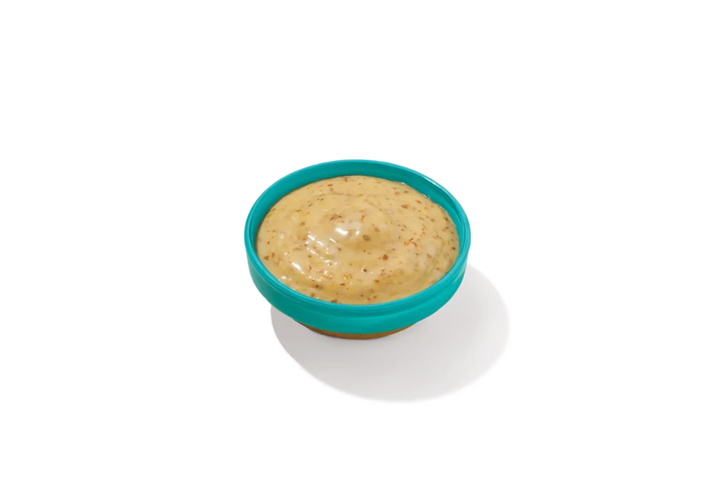 "Bowl of Mardi Gras Mustard on a white background."