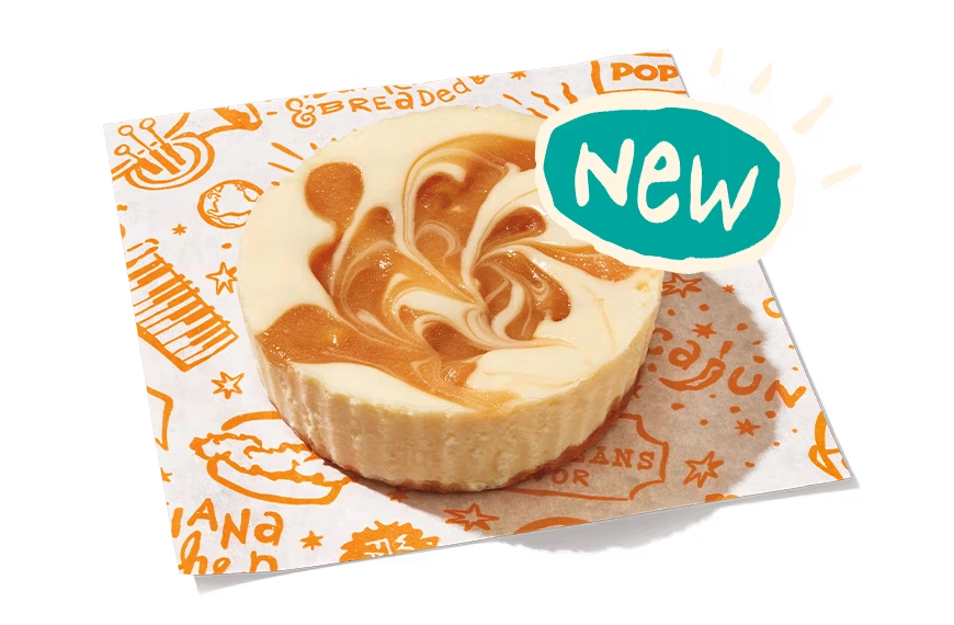 "New caramel apple cheesecake cup with swirled caramel topping on branded paper, labeled 'Caramel Apple Cheesecake Cup.'"