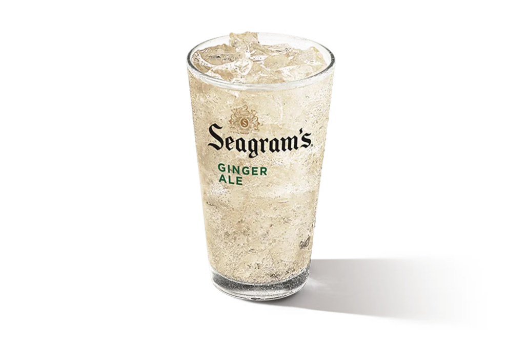 "Glass of Seagram's Ginger Ale with ice cubes, Seagram's logo on the glass, on a white background."