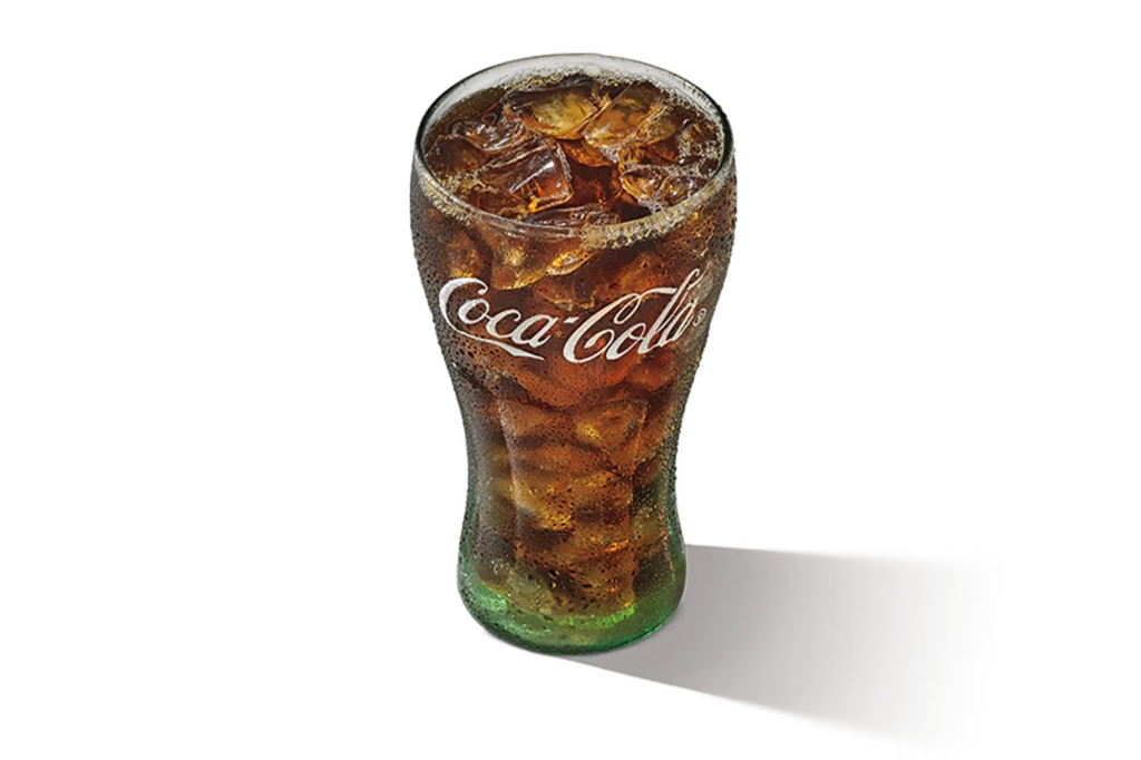 "Glass of Coca-Cola Zero Sugar with ice cubes, branded logo visible, on a white background."