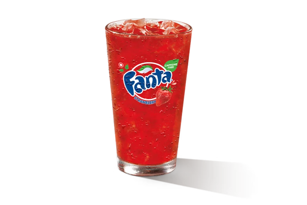 "Glass of Fanta Strawberry with ice cubes, Fanta logo on the glass, on a white background."