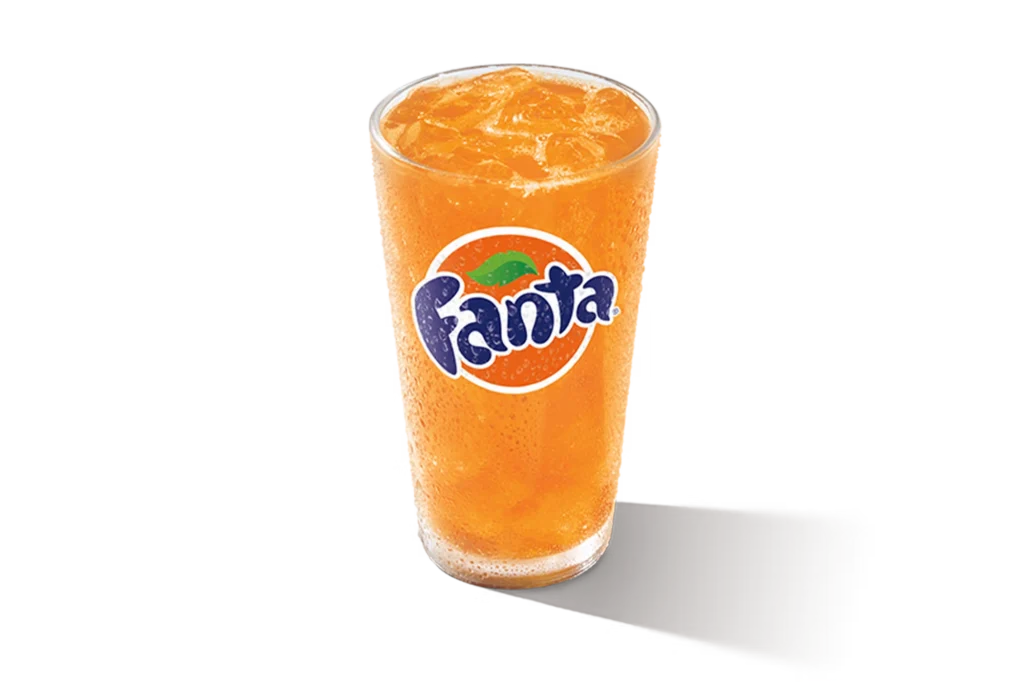"Glass of Fanta Orange with ice cubes, Fanta logo on the glass, on a white background."