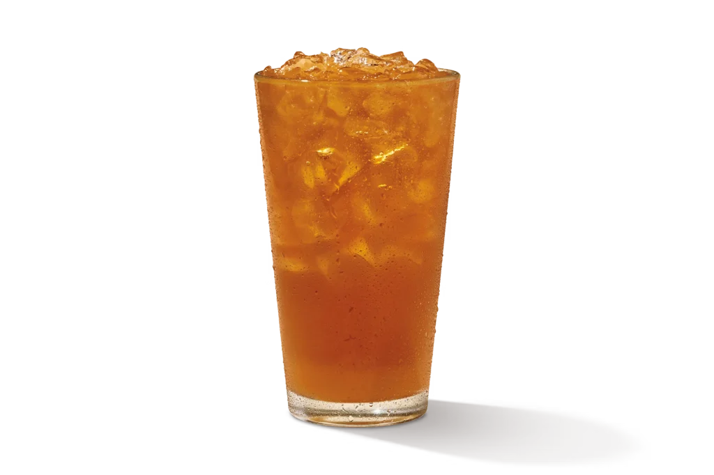 "Glass of Mango Unsweet Tea with ice cubes, on a white background."