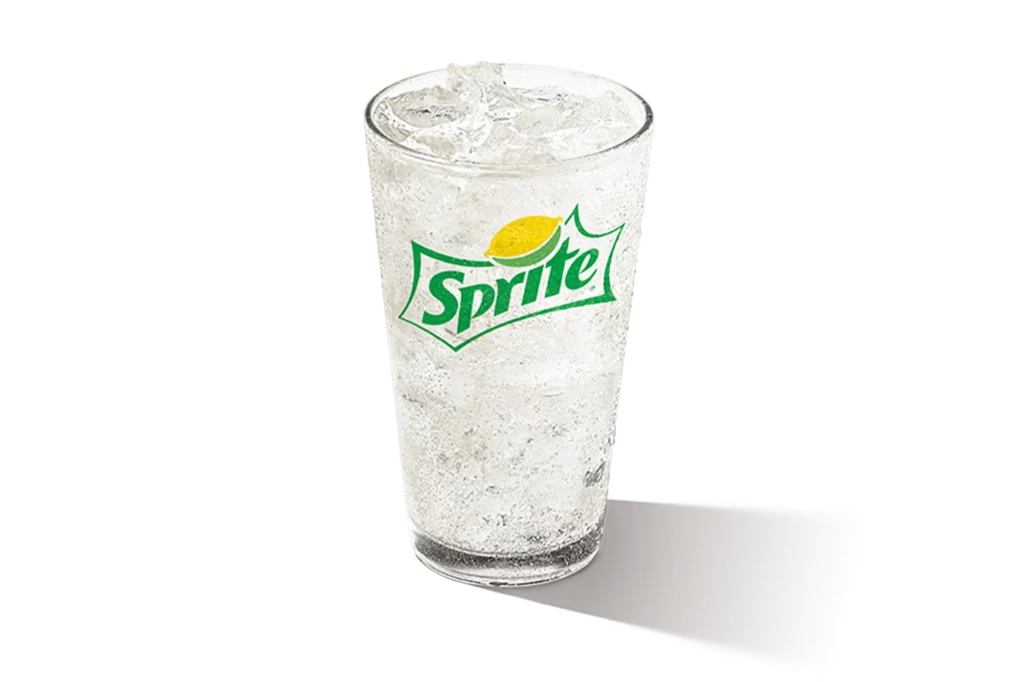 "Glass of Sprite with ice cubes, Sprite logo visible, on a white background."