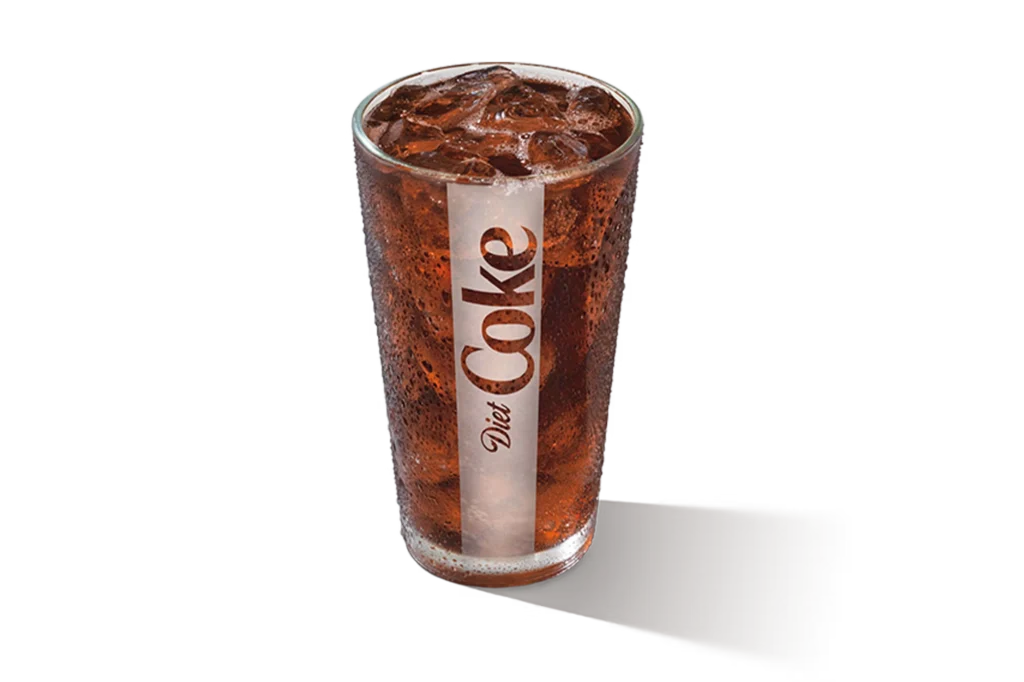 "Glass of Diet Coke with ice cubes, Diet Coke logo on the glass, on a white background."