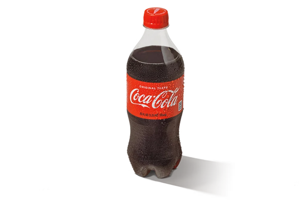 "20oz bottle of Coca-Cola with red cap and label, standing upright on a white background."